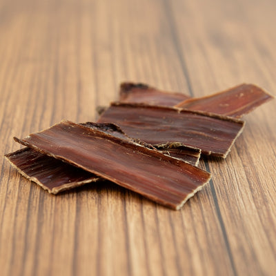 Dried beef jerky pieces on a white background