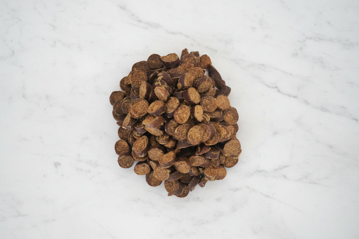 Pile of brown dog treats on a white background