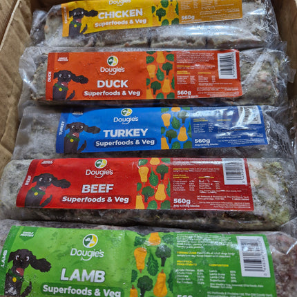 Packaged dog food products with colorful labels on a cardboard surface
