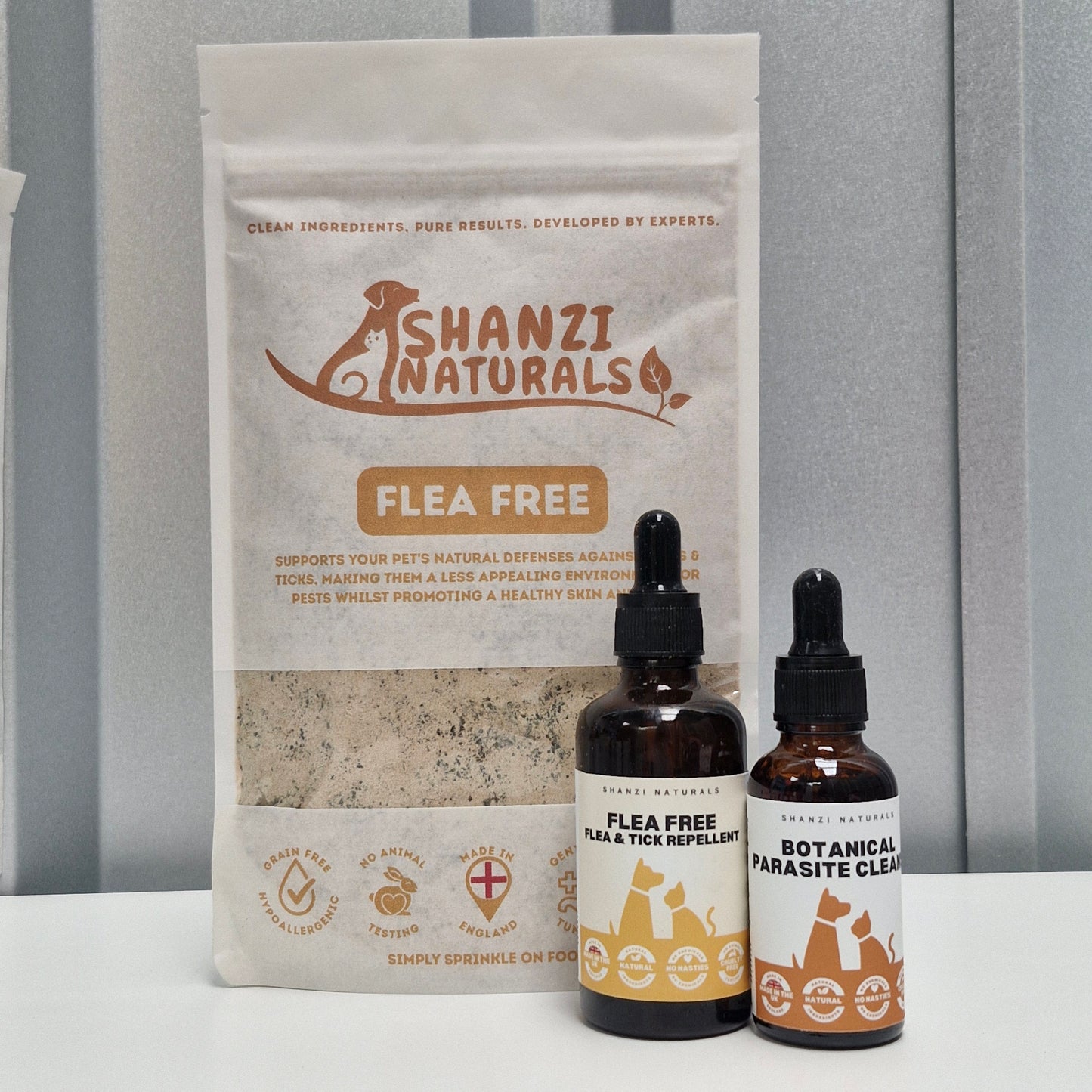 Shanzi Naturals flea-free product packaging with two dropper bottles on a gray background
