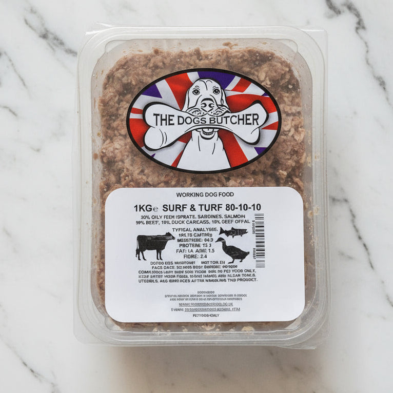 Container of dog food with 'The Dogs Butcher' label on a white surface